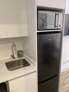 马德里Plaza Castilla Apartments的厨房配有黑色冰箱和水槽