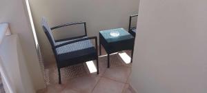 圣玛丽亚Oasis Palmeira的一间房间,配有三把椅子、一张桌子和一扇门