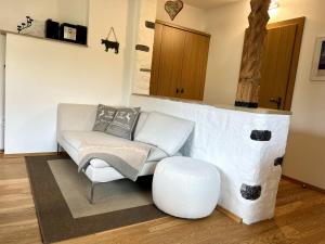 埃尔瓦尔德Haus Bläsi的客厅配有白色沙发和凳子
