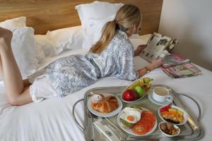 加的斯蒙泰波尔塔提亚拉酒店的躺在床上的女人,带上一盘食物