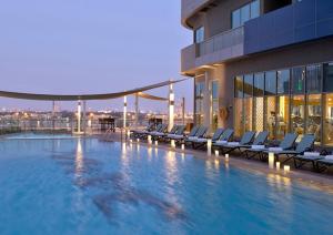 迪拜Downtown Luxury - 5 star Hotel Facilities - 5 min walk to Dubai Mall的一座带椅子的建筑的顶部游泳池