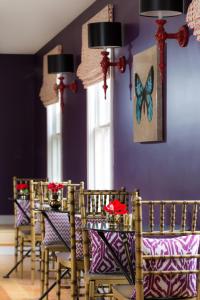 纽波特镀金酒店的一间拥有紫色墙壁和桌椅的用餐室