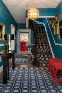 纽波特镀金酒店的一间拥有蓝色墙壁的客房和一个带红色长凳的楼梯