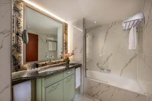 柏林JW Marriott Hotel Berlin的一间带水槽、浴缸和镜子的浴室
