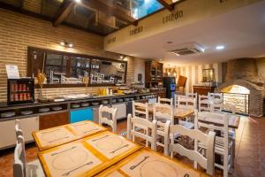 托莱多YIT Puerta Bisagra的餐厅设有木桌、白色椅子和柜台