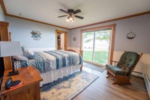 Beautiful home on Lake Michigan, near Escanaba的卧室配有床、椅子和窗户。