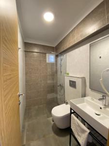达特恰Gülhan City Otel的浴室配有卫生间、盥洗盆和淋浴。