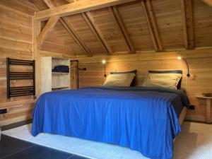 The Miller's Lodge B&B的小木屋内一间卧室配有一张蓝色的床