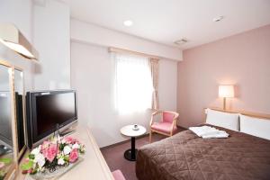 仙台尤丽斯特森戴经济酒店的配有一张床和一台平面电视的酒店客房