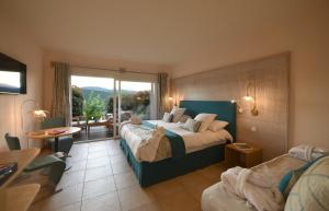 维琪奥港Hôtel Alivi Di Santa Giulia的酒店客房设有两张床和大窗户。