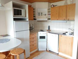 塔库沃里Rivitalon huoneisto Tahkolla的厨房配有白色家电和木制橱柜