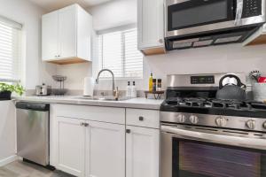 圣地亚哥Urban Oasis: San Diego Bungalow Escape的厨房配有白色橱柜和炉灶烤箱。