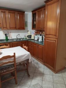 GiuggianelloCasa vacanza EliMari - Salento的厨房配有木制橱柜和桌子。