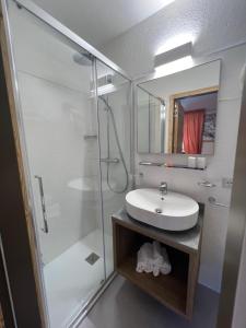 库马约尔德格拉斯尔酒店的浴室配有白色水槽和淋浴。