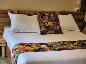 阿鲁沙Haradali's Home的一张带被子和两个枕头的床
