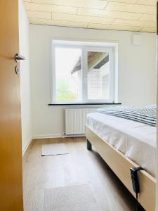 库拉萨Scandinavian House Hotel- Holbøl, Kruså的一间卧室设有一张床和一个窗口
