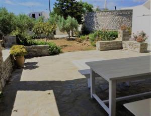 DhragoulásParos spacious apartment的花园里的一张野餐桌,花园里设有石墙