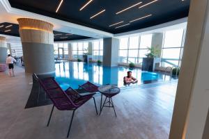 科威特Grand Hotel的坐在建筑物游泳池里的人