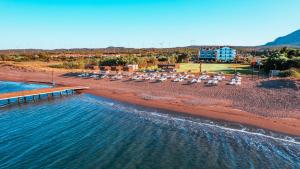 达特恰Acroter Hotel Spa - Alcohol Extra All Inclusive的享有海滩的空中景致,配有椅子和码头