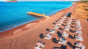 达特恰Acroter Hotel Spa - Alcohol Extra All Inclusive的享有海滩的空中景致,配有椅子和遮阳伞