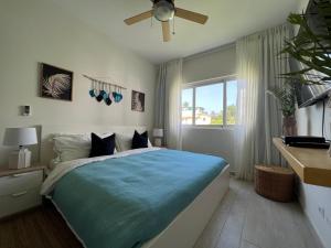 蓬塔卡纳Casa Mulata Paseo del Mar Pool & Playa的一间卧室配有一张带蓝色棉被的床和窗户。
