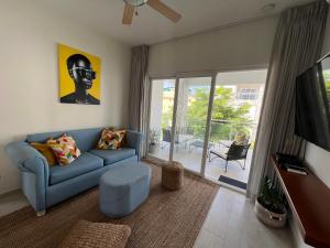 蓬塔卡纳Casa Mulata Paseo del Mar Pool & Playa的客厅配有蓝色的沙发和电视