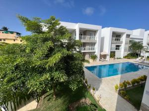 蓬塔卡纳Casa Mulata Paseo del Mar Pool & Playa的公寓大楼设有游泳池和树