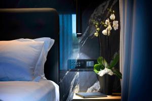 西尔米奥奈Boutique Hotel Sirmione的一间卧室设有一张床和一个花瓶的窗户