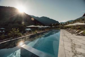 格罗萨尔Familien Natur Resort Moar Gut的度假村的游泳池配有椅子和遮阳伞
