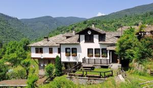 科瓦切维卡Къща за гости Далеч от морето的山丘上以山为背景的房子