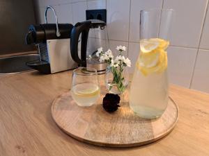 德累斯顿Gemütliche helle Ferienwohnung的一瓶柠檬水和两杯台面上的眼镜