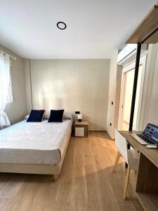 瓦伦西亚Habitación bien situada, cómoda y nueva的一间卧室配有一张床、一张书桌和一台笔记本电脑