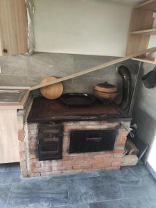图兹拉Vikendica Majevicka Oaza的厨房配有砖炉顶上的2台木器 ⁇ 