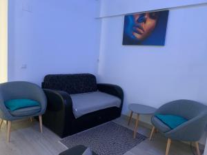 克拉约瓦Black&White Suites的一间设有两把椅子和一张桌子的房间