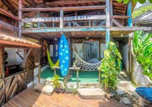 伊塔卡雷Pousada Boas Ondas的房屋设有带吊床的甲板和游泳池