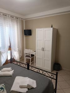 科皮托Il Roseto的一间卧室配有床和一个带毛巾的橱柜。