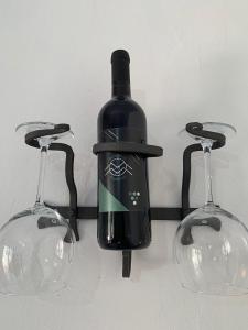 多尔加利Turismo Rurale Belvedere Pradonos的一瓶葡萄酒挂在两杯酒杯之间