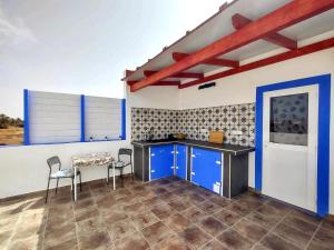 大塔拉哈尔Suite Estrella Azul的厨房配有蓝色橱柜和桌椅