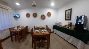 蓬塔德尔加达Hotel Insular的一间设有两张桌子的餐厅和一个提供食物的柜台