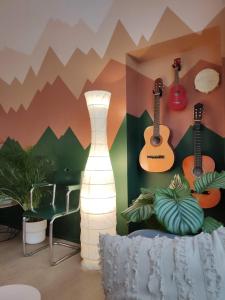 都灵绿竹生态旅舍的墙上有吉他的房间和一盏灯