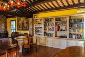 皮耶韦城Agriturismo Dandelion的藏有白色橱柜、桌子和书架的图书馆