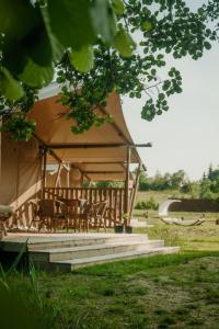 ŁowyńFreedolina Glamping的田野上带桌椅的大型帐篷