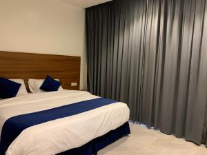 Al Namasاجنحة ريام的一间卧室配有一张大床和黑色窗帘
