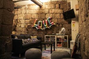 波尔图Onefam Ribeira的带沙发和石墙的客厅