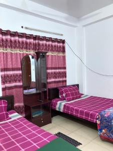达卡Mohammadia Restaurant & Guest House Near United Hospital的带两张床和镜子的客房