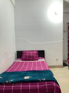 达卡Mohammadia Restaurant & Guest House Near United Hospital的卧室配有粉色和紫色的床和紫色枕头