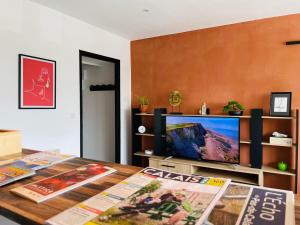 加来La Brise Marine的客厅配有电视和带杂志的桌子。