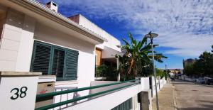 克洛伊奥斯Quarto Duplo com Kitchenette, WC e Pátio privativo的街道旁的白色房屋,设有围栏