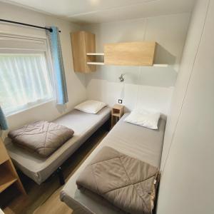 La Ville-aux-Dames阿加西亚斯露营地的小房间设有两张床和窗户