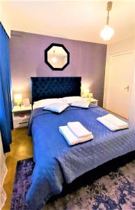 布加勒斯特Arc de Triomphe BlissBoutique的一间卧室配有蓝色的床和2条毛巾